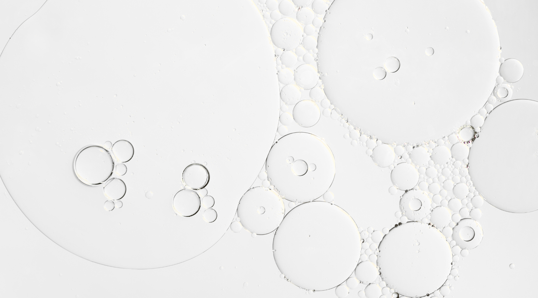 clear skincare serum with bubbles on a light gray background