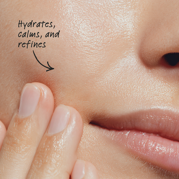 Close-up of smooth skin with text 'Hydrates, calms, and refines' and a hand touching the skin.