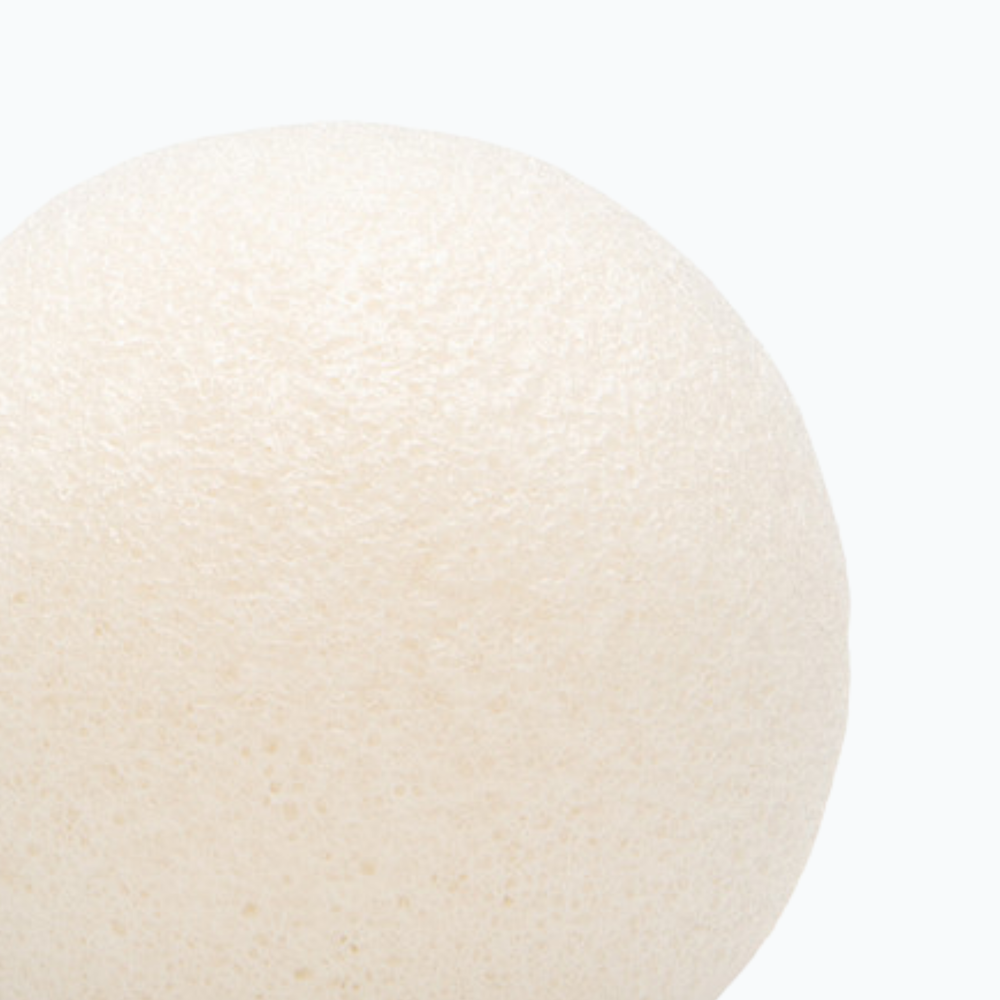 Round konjac facial sponge on a neutral 
background