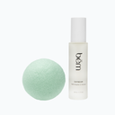 Daybeam serum bottle and a green tea konjac sponge on a white background.