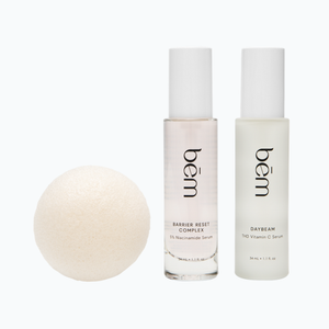 Two Bēm serum bottles and a round facial sponge on a neutral background