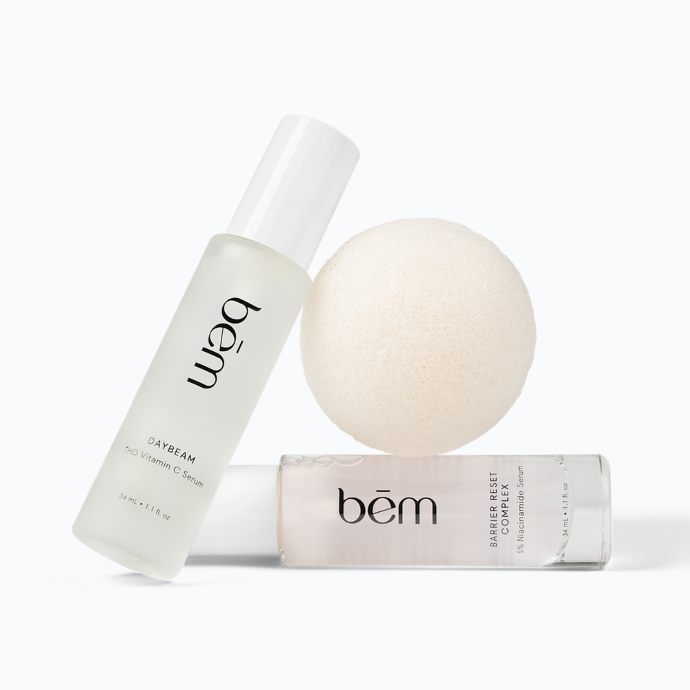 Two Bēm serum bottles and a round facial sponge on a neutral background