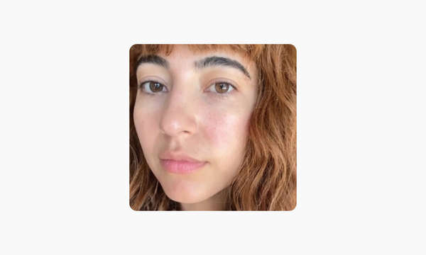 Close-up of a woman with brownish-red hair and bangs on a white background