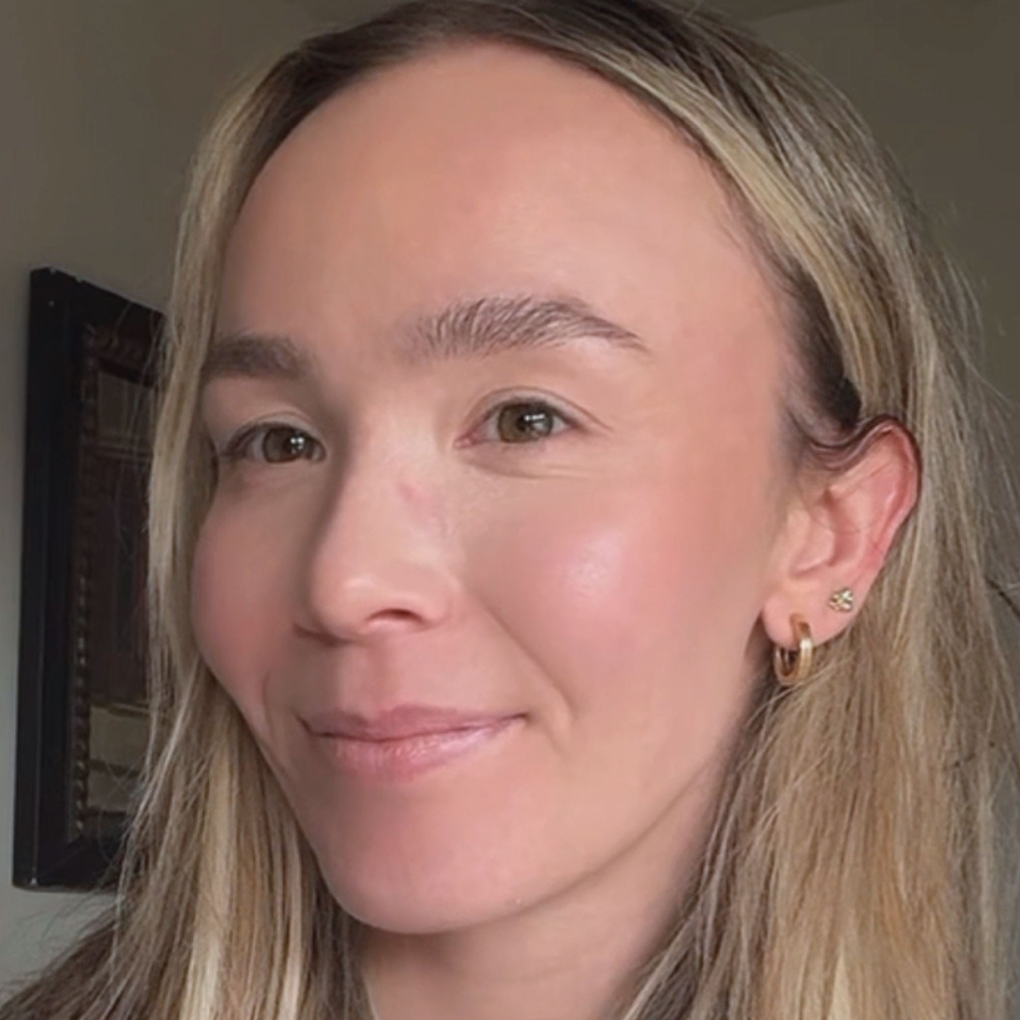 Close-up of a woman with blonde hair and a soft smile.