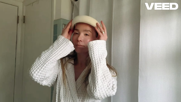 Woman in bathroom applying Bēm's Daybeam vitamin c serum while giving testimonial.